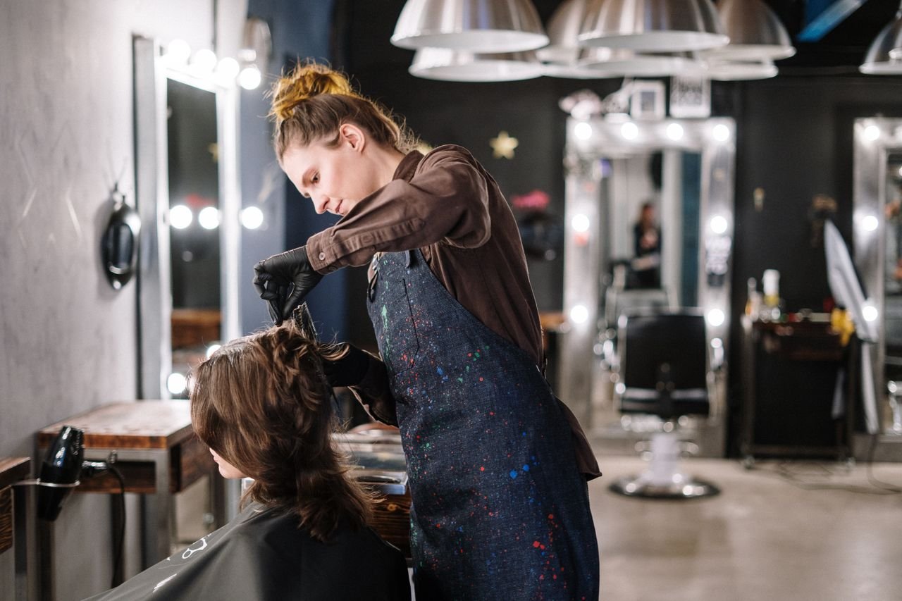 Mastering the First Impression: Your intriguing post title goes here A female stylist expertly applying hair color to a client in a modern salon setting.